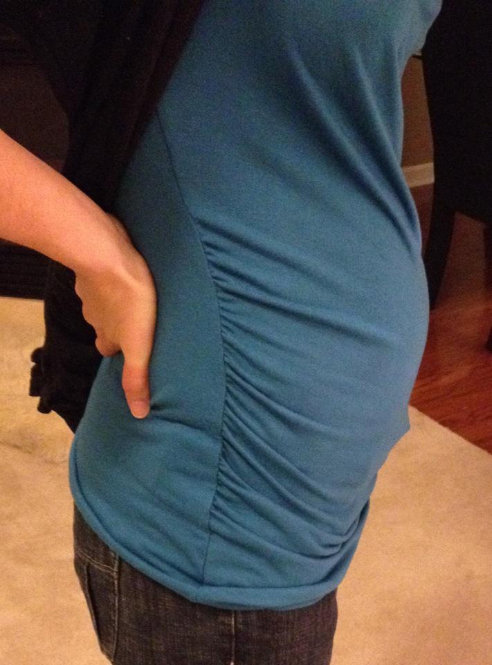 Early baby bump in a teal top